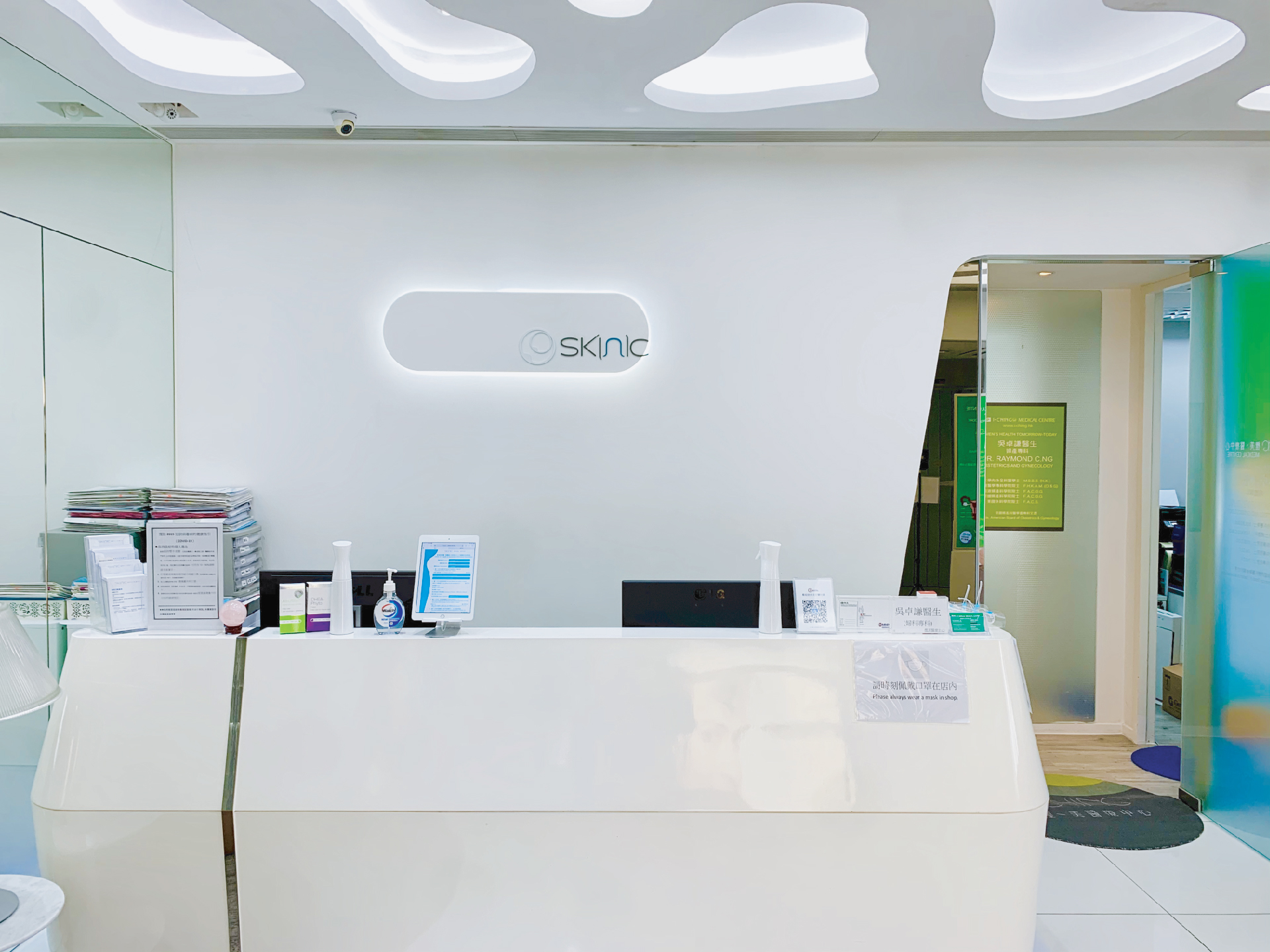 Skinic beauty reception area featuring a modern, minimalist design with a white desk and soft lighting.